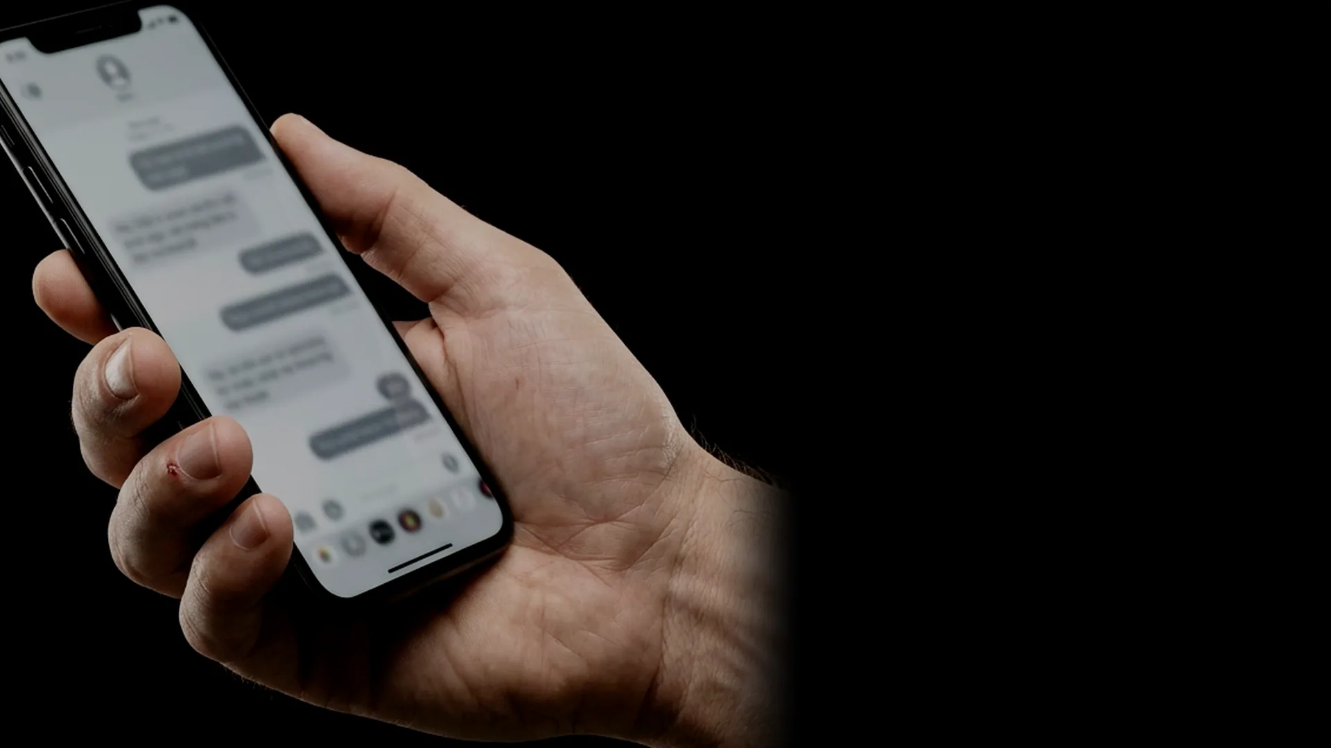 Una mano sostiene un celular con una conversación abierta